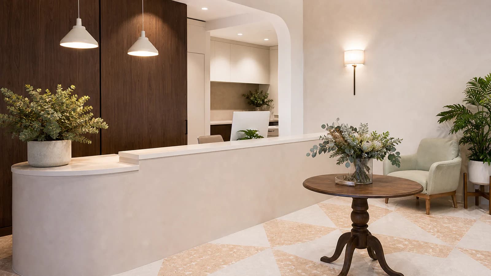 Warm reception area at Her Health and Aesthetics with cream counters and timber finishes